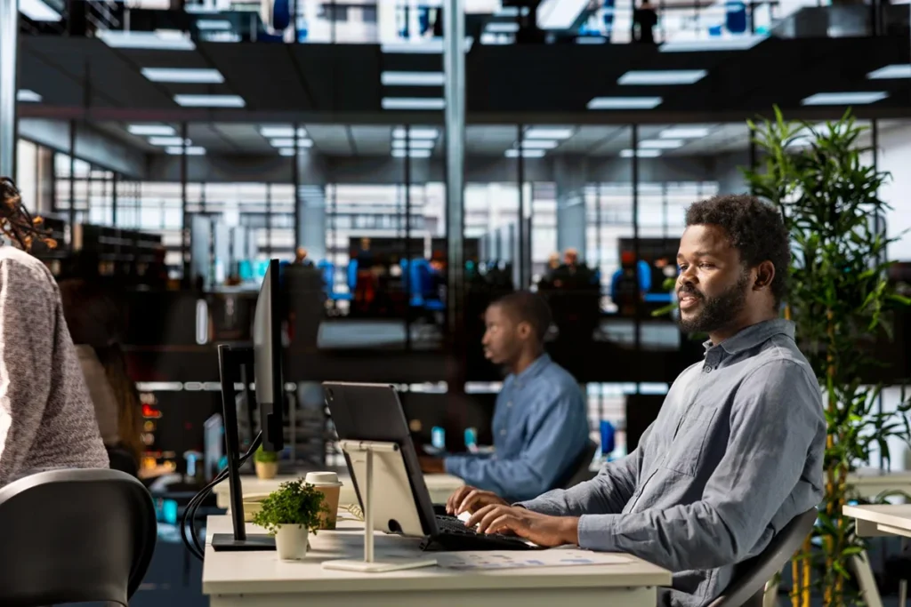 Técnico de informática prestando consultoria de TI em um escritório em São Paulo, focado em suporte técnico corporativo.